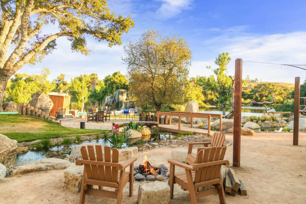 serene camping area with wooden chairs around a small fire pit